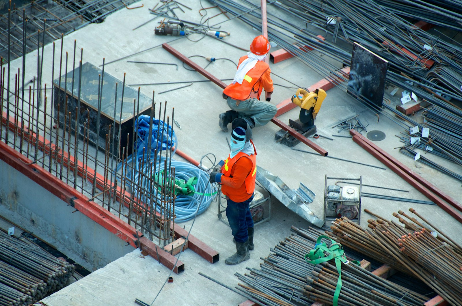 Chantier BTP en lumière dure avec structure béton et outils de terrain